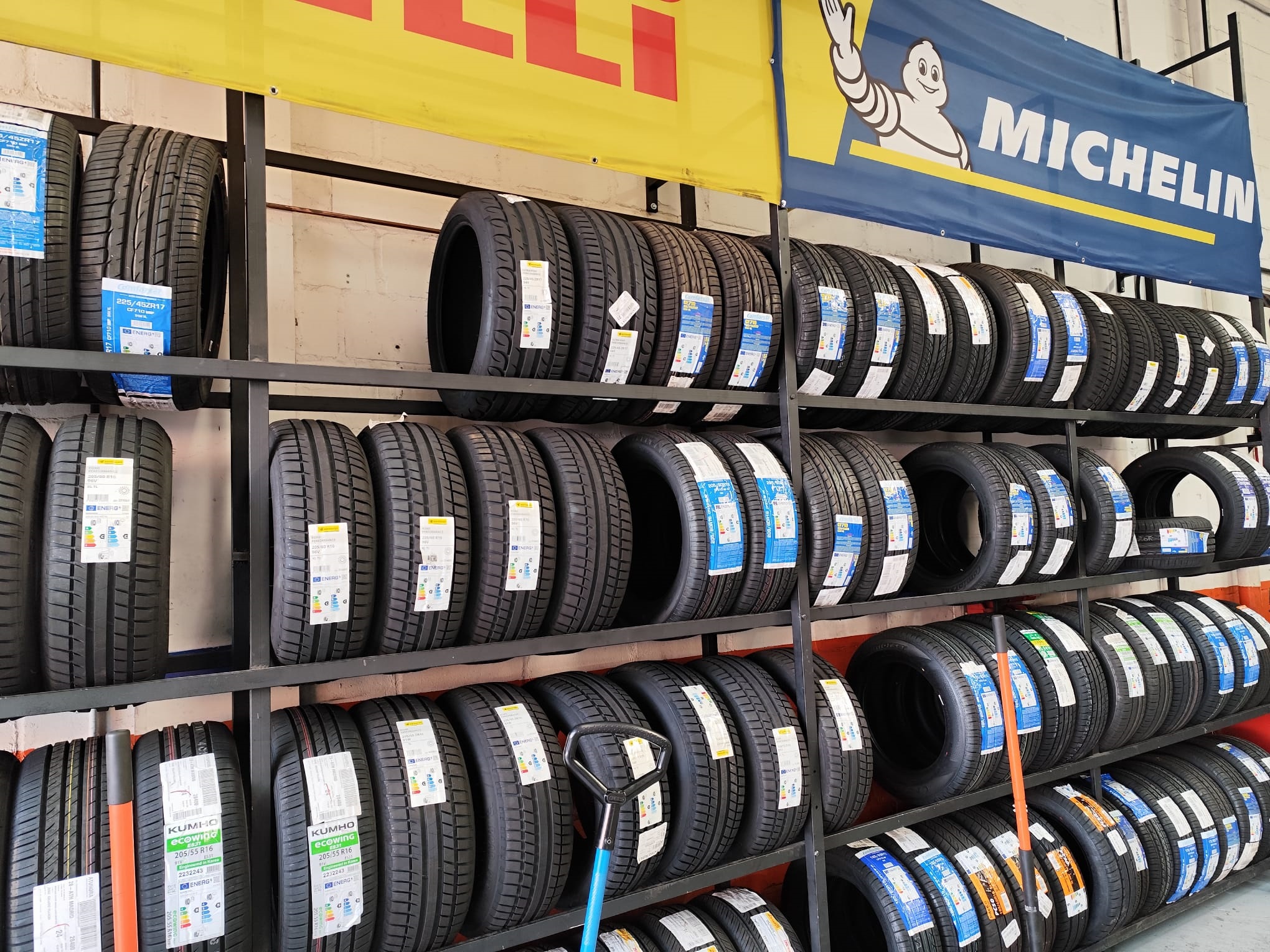 Neumáticos de marcas como Michelin y Pirelli en estanterías de taller en Villalba